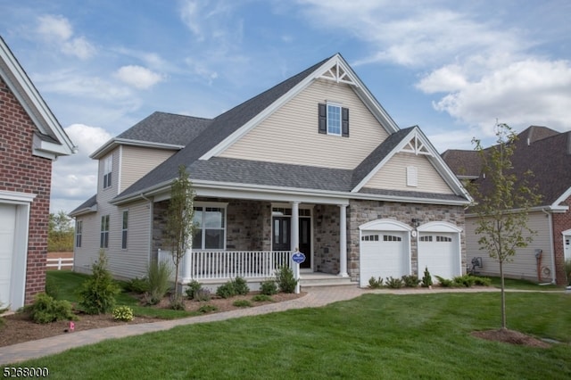 view of front of home featuring a front lawn, covered porch, and a garage