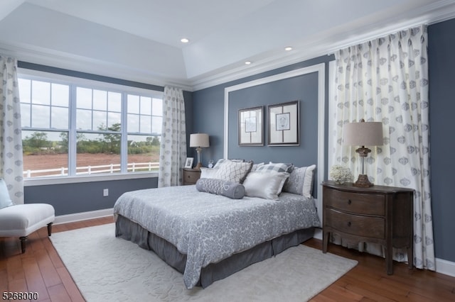 bedroom featuring crown molding, a tray ceiling, and hardwood / wood-style flooring