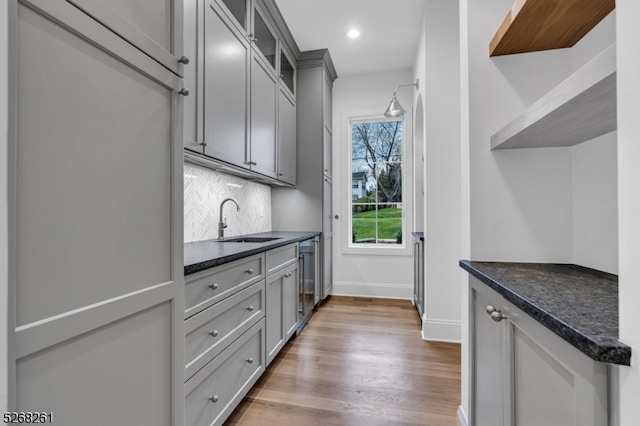 kitchen with sink, gray cabinets, tasteful backsplash, wine cooler, and hardwood / wood-style floors