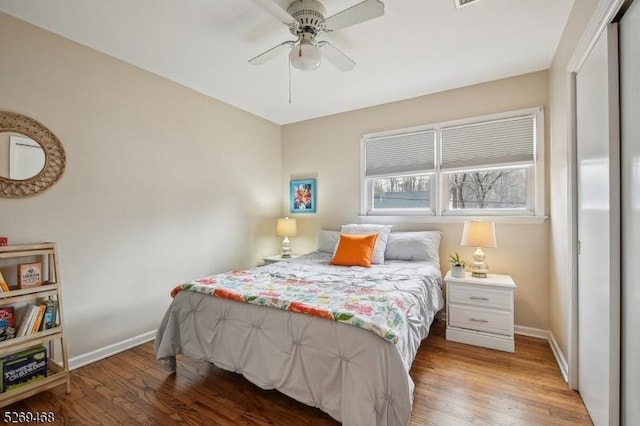 bedroom with ceiling fan, baseboards, and wood finished floors