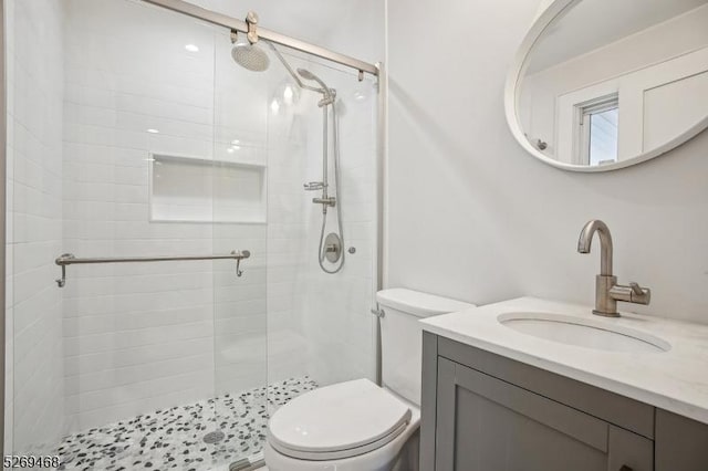 bathroom featuring a stall shower, vanity, and toilet