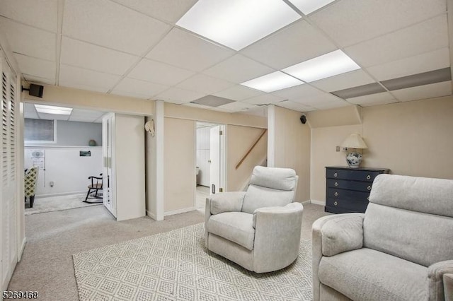 living room with carpet floors, a drop ceiling, and baseboards