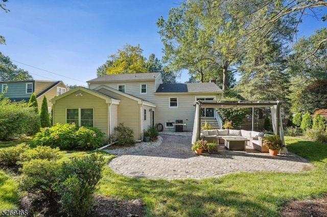 back of house featuring a patio, a yard, and an outdoor living space