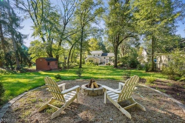 view of yard with an outbuilding, a fire pit, and a shed