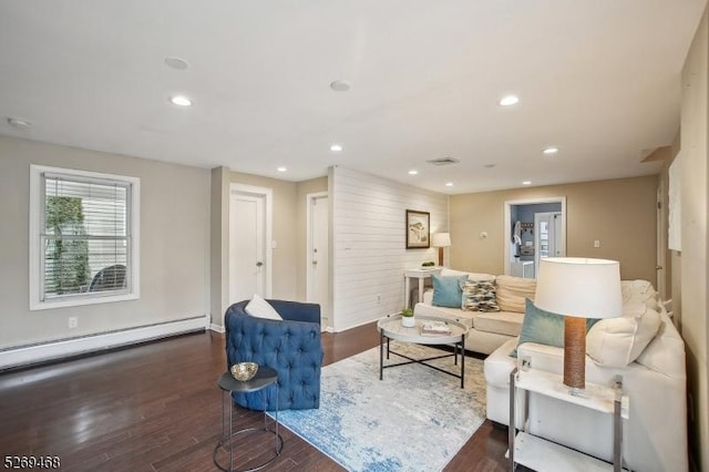 living room featuring a baseboard heating unit, wood finished floors, visible vents, and recessed lighting