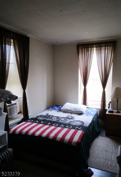 bedroom featuring cooling unit and multiple windows