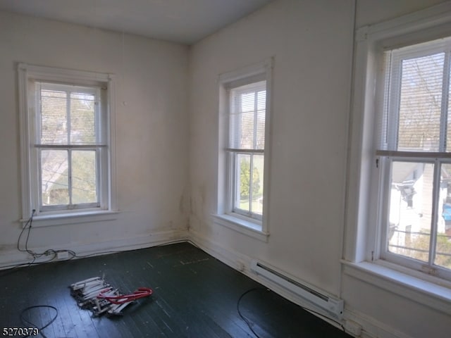 empty room with a baseboard radiator and hardwood / wood-style flooring