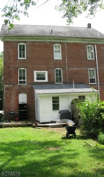 back of property featuring a yard