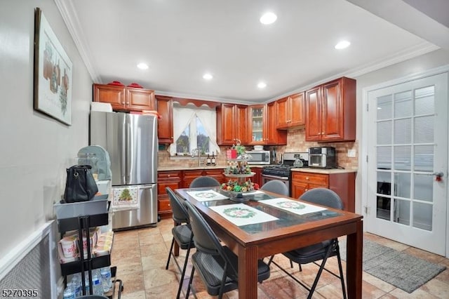 kitchen featuring appliances with stainless steel finishes, tasteful backsplash, ornamental molding, and sink