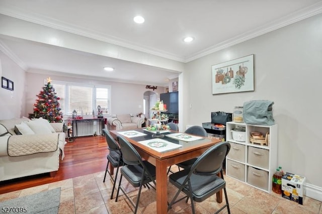 dining space with wood-type flooring, ornamental molding, and radiator