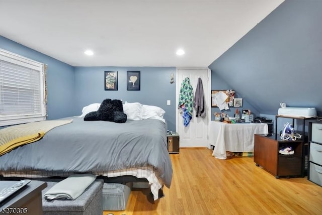 bedroom with light hardwood / wood-style floors and lofted ceiling