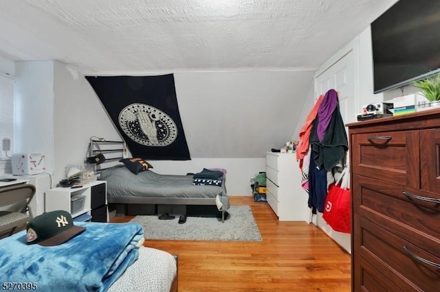 bedroom with a textured ceiling and light hardwood / wood-style flooring