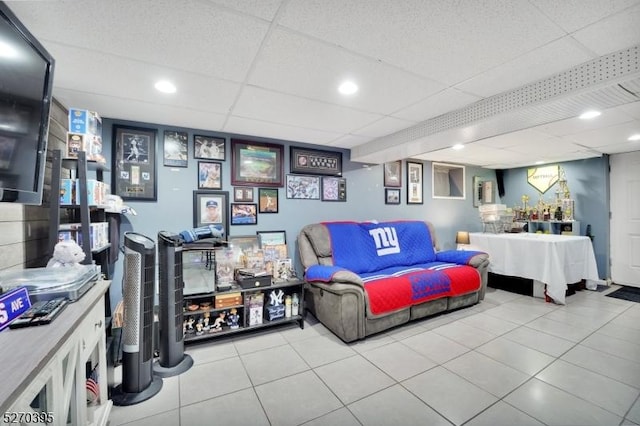 tiled living room featuring a paneled ceiling