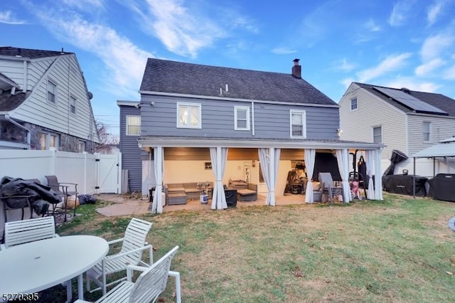 back of house with outdoor lounge area, a yard, and a patio