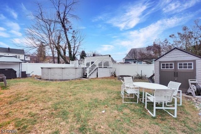 view of yard featuring a fenced in pool and a storage shed