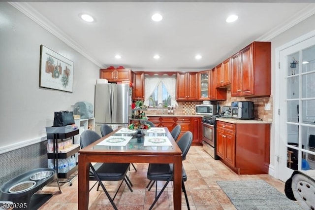 kitchen with tasteful backsplash, ornamental molding, stainless steel appliances, sink, and light tile patterned floors