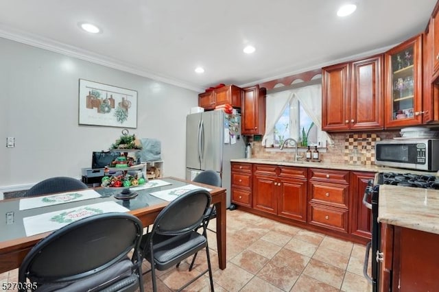 kitchen with backsplash, light stone counters, stainless steel appliances, crown molding, and sink