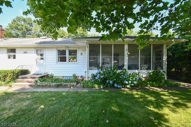 back of house featuring a sunroom and a yard