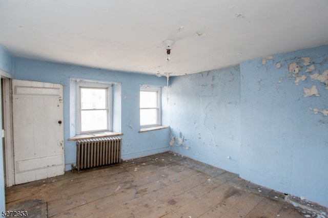 empty room featuring radiator heating unit and wood-type flooring
