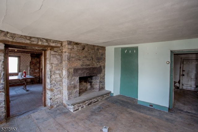 unfurnished living room with a stone fireplace