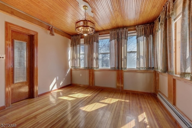 empty room featuring a baseboard radiator, an inviting chandelier, wood ceiling, and light wood-type flooring