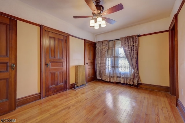 unfurnished bedroom featuring ceiling fan, light hardwood / wood-style flooring, and radiator