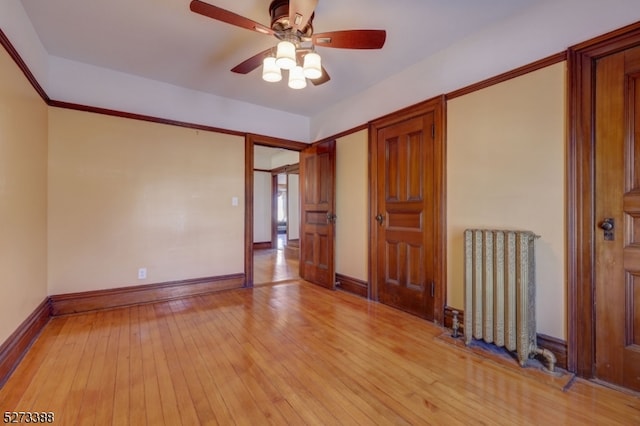 interior space featuring light wood-type flooring, ceiling fan, and radiator