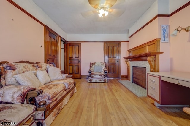 living room with light hardwood / wood-style floors, ceiling fan, and a fireplace