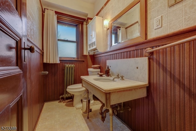 bathroom with sink, tile flooring, radiator, and toilet