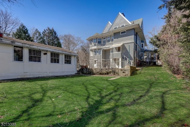 rear view of house featuring a yard