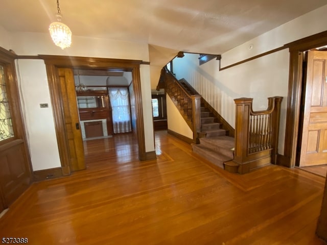 entrance foyer with hardwood / wood-style floors and an inviting chandelier