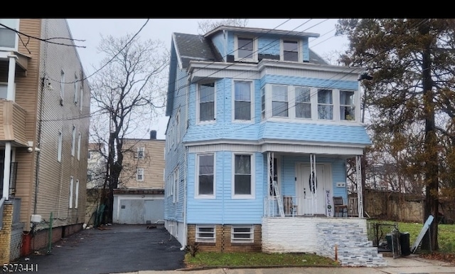 view of front of home featuring a porch and an outdoor structure