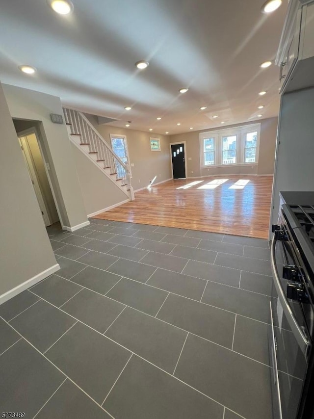 unfurnished living room featuring a wealth of natural light and dark wood-type flooring