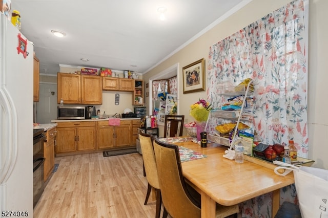 kitchen with range, stainless steel microwave, light hardwood / wood-style floors, crown molding, and white refrigerator