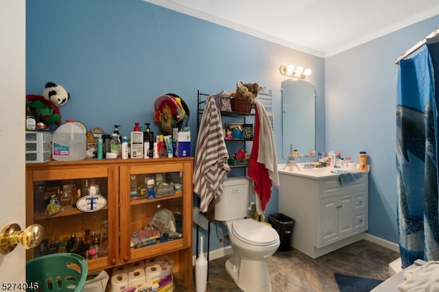 bathroom featuring toilet, ornamental molding, and vanity