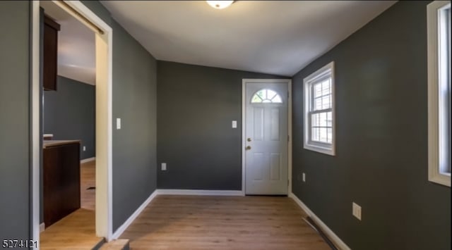 foyer featuring lofted ceiling and light wood-type flooring