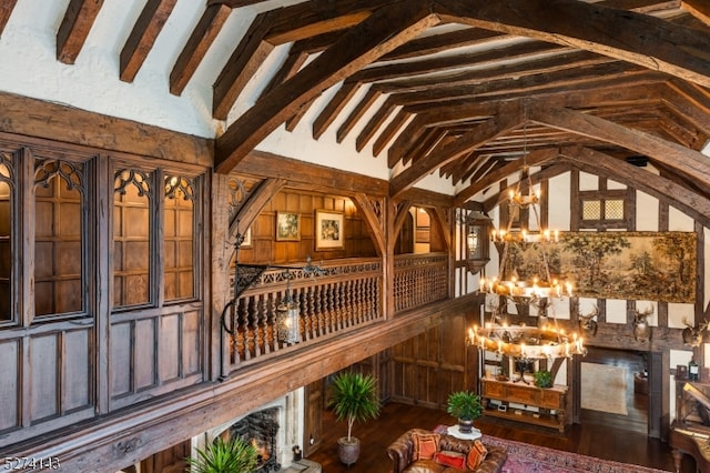 interior space with lofted ceiling with beams, dark wood-type flooring, and a notable chandelier