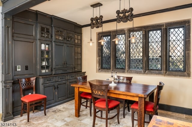 dining space with ornamental molding and a notable chandelier