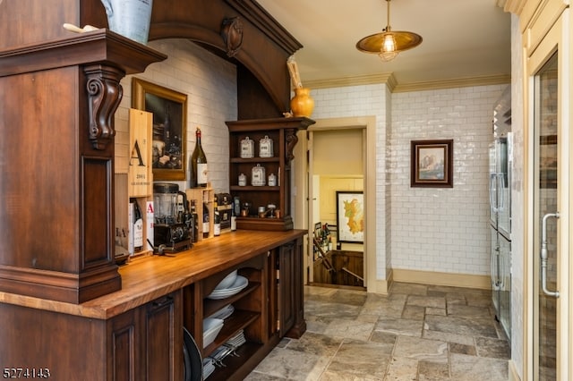 bar with crown molding, brick wall, and wood counters