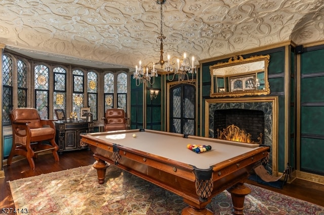 playroom featuring a high end fireplace, dark hardwood / wood-style flooring, billiards, and an inviting chandelier