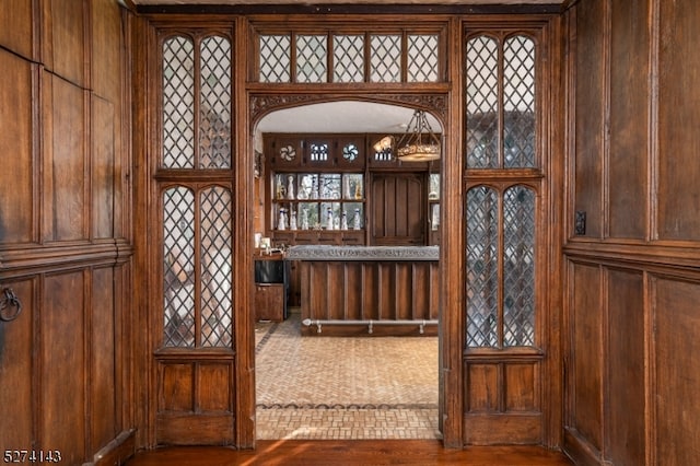 interior space with hardwood / wood-style flooring and wooden walls