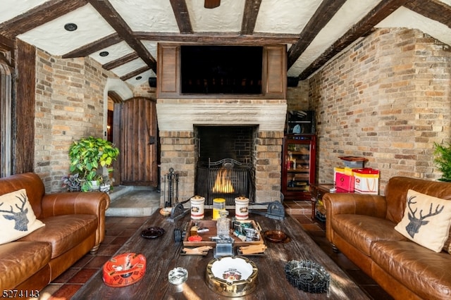 living room featuring a fireplace, lofted ceiling with beams, and brick wall