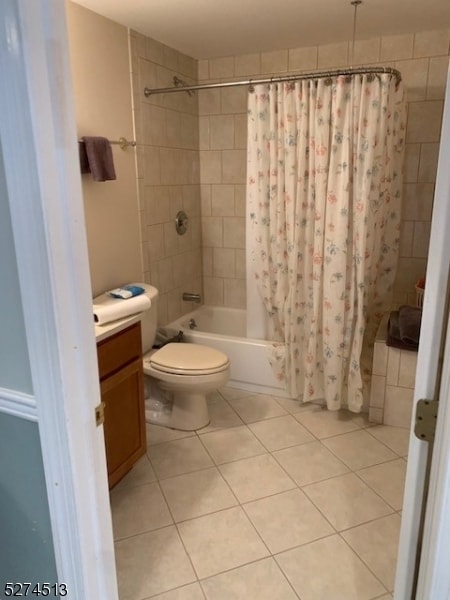 full bathroom with tile floors, shower / tub combo with curtain, vanity, and toilet