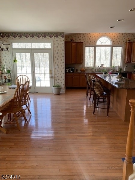 kitchen featuring dark stone counters, light hardwood / wood-style flooring, and a breakfast bar area