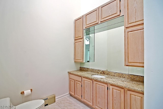 bathroom featuring toilet, vanity, a baseboard radiator, and tile flooring