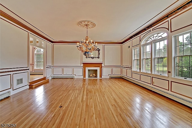 unfurnished room with crown molding, light hardwood / wood-style flooring, and a chandelier