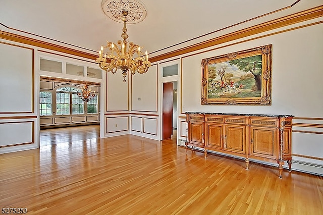 interior space featuring light wood-type flooring, ornamental molding, and a chandelier