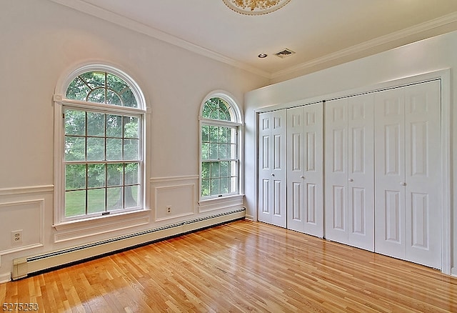 unfurnished bedroom with light hardwood / wood-style floors, ornamental molding, and a baseboard radiator