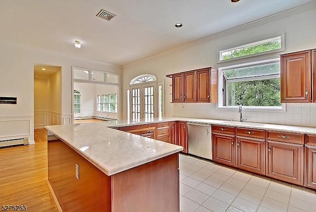 kitchen featuring a wealth of natural light, tasteful backsplash, french doors, stainless steel dishwasher, and sink