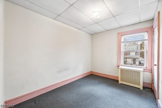 carpeted spare room with a paneled ceiling and radiator